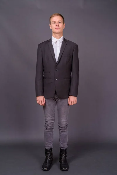 Ritratto di giovane bell'uomo d'affari su sfondo grigio — Foto Stock