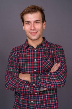 Gri arka planda genç yakışıklı bir adamın portresi