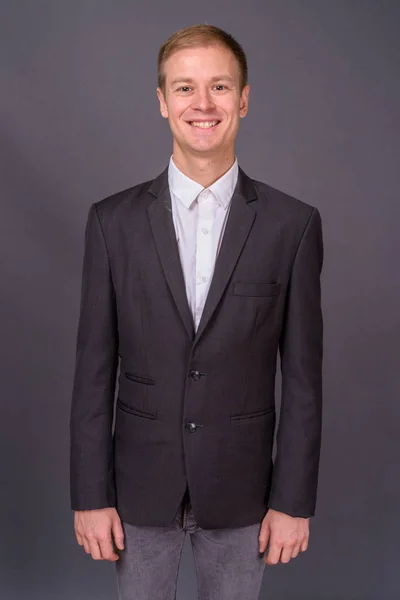 Портрет молодого красивого бізнесмена на сірому фоні — стокове фото
