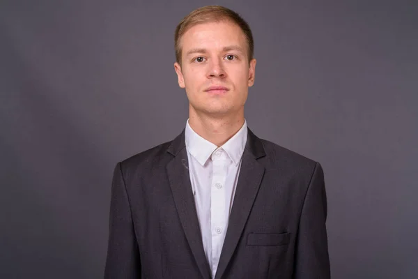 Retrato de joven hombre de negocios guapo sobre fondo gris — Foto de Stock