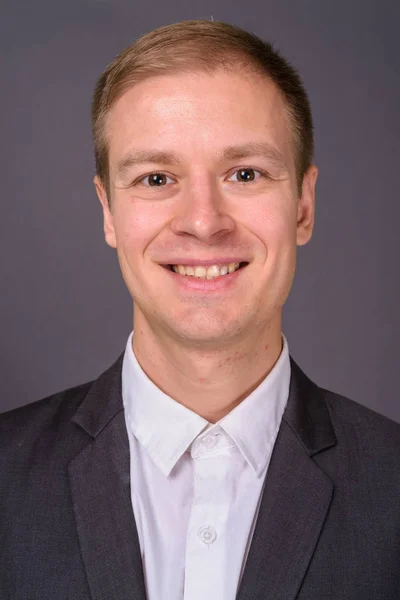 Retrato de joven hombre de negocios guapo sobre fondo gris — Foto de Stock