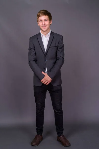 Retrato de joven hombre de negocios guapo sobre fondo gris — Foto de Stock