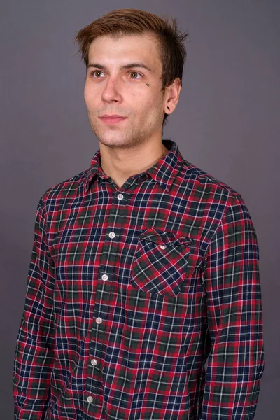 Retrato de un joven guapo sobre fondo gris —  Fotos de Stock