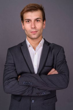 Genç yakışıklı işadamı gri arka plan portait