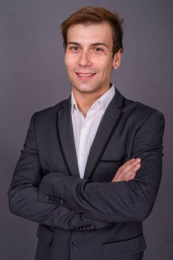 Genç yakışıklı işadamı gri arka plan portait