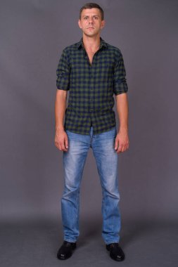 Gri arka planda kısa saçlı yakışıklı adam.