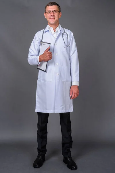 Hombre guapo doctor con pelo corto sobre fondo gris —  Fotos de Stock