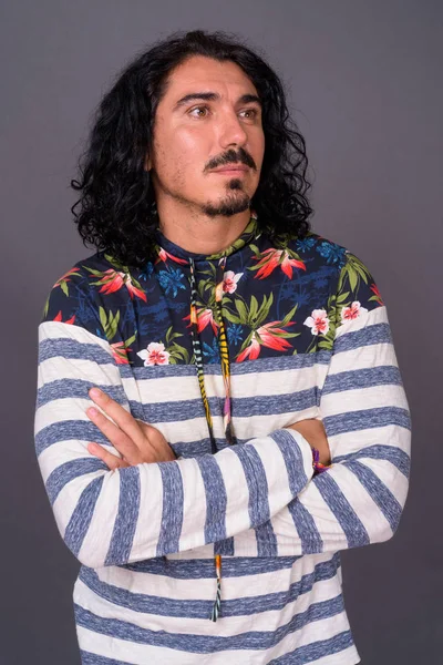 Hombre guapo con pelo rizado y bigote contra fondo gris — Foto de Stock