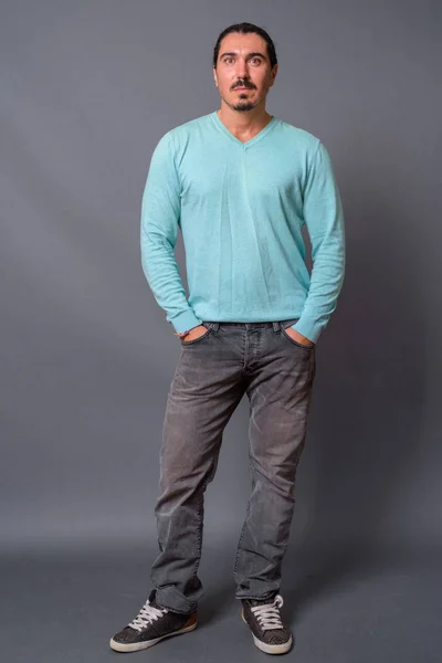 Hombre guapo con pelo rizado y bigote contra fondo gris — Foto de Stock