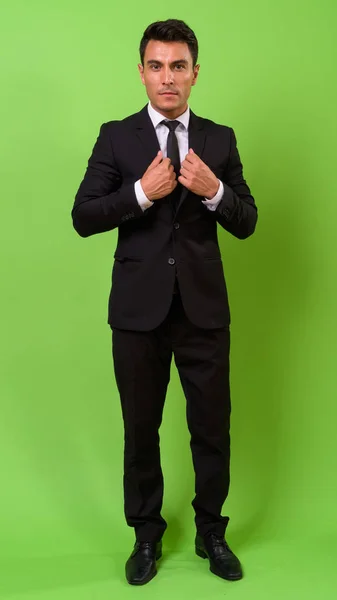 Junger hübscher hispanischer Geschäftsmann vor grünem Hintergrund — Stockfoto