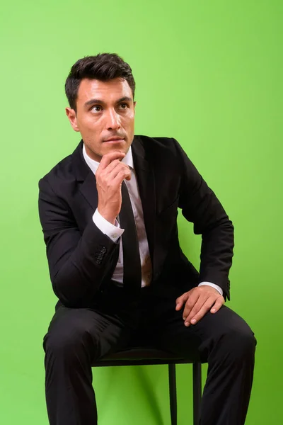 緑の背景に若いハンサムなヒスパニック系実業家 — ストック写真