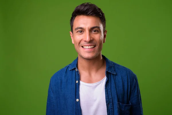 Jovem bonito hispânico homem contra fundo verde — Fotografia de Stock