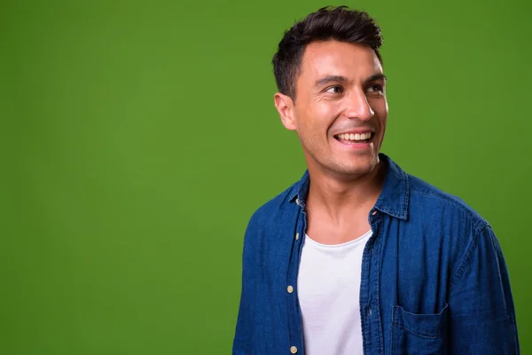 緑の背景に若いハンサムなヒスパニック系男性 — ストック写真