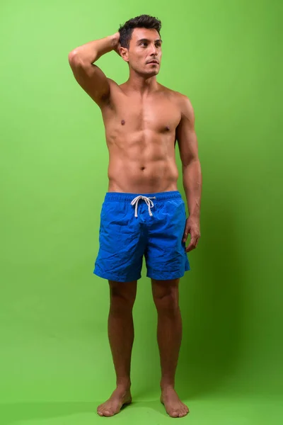 Joven hombre hispano guapo sin camisa sobre fondo verde — Foto de Stock