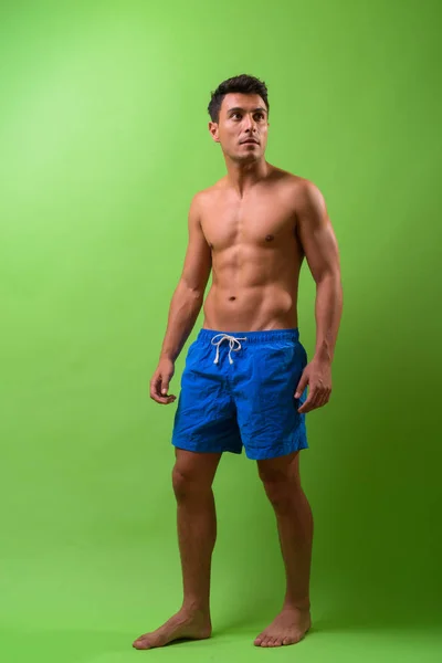 Joven hombre hispano guapo sin camisa sobre fondo verde — Foto de Stock