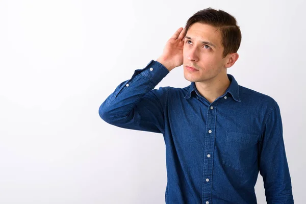 Studio shot van de knappe jongeman luisteren tijdens het denken weer — Stockfoto