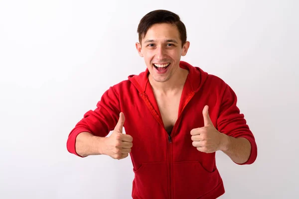 Studio shot of happy young handsome man smiling while giving thu — Stock Photo, Image