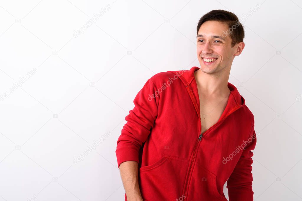 Studio shot of happy young handsome man smiling while looking to