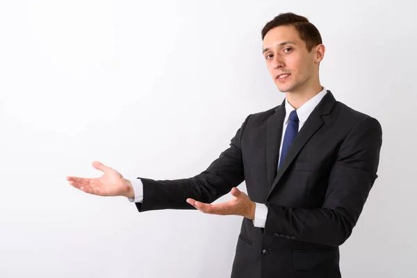 Studio shot of young handsome businessman showing something agai — Stock Photo, Image