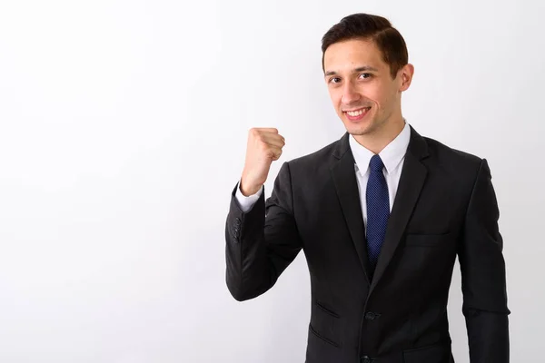 Studioaufnahme eines jungen glücklichen Geschäftsmannes, der lächelt, während er mot sieht — Stockfoto