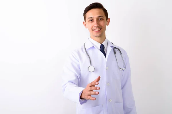 Estudio de tiro de joven feliz hombre médico sonriendo mientras da las manos — Foto de Stock