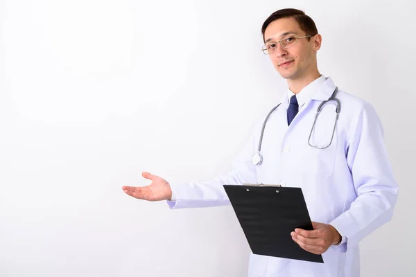 Студійний знімок молодого красивого чоловіка лікар показує щось і h — стокове фото