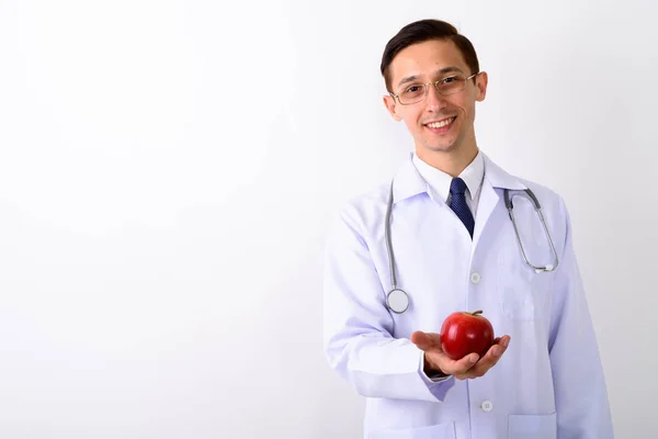 Студійний знімок молодого щасливого лікаря, який посміхається, тримаючи червоний — стокове фото