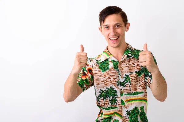 Estúdio tiro de jovem turista feliz homem sorrindo ao dar thum — Fotografia de Stock