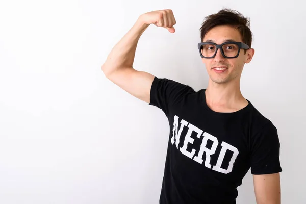 Studio shot of young happy nerd man smiling while flexing arm an — Stock Photo, Image