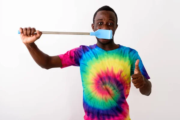 Studio colpo di giovane nero africano uomo utilizzando grande pulizia spazzola — Foto Stock