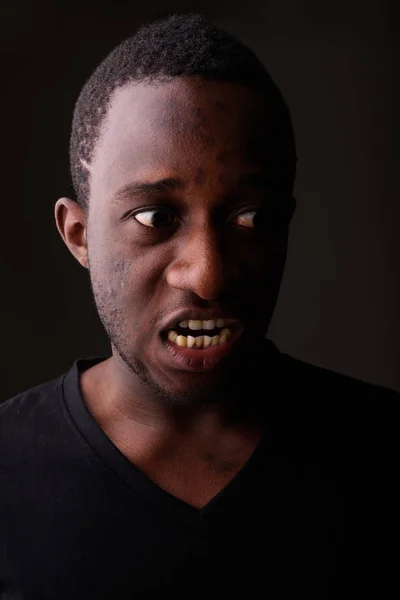 Strzał studio zły młodych Afryki Murzyn krzyczy w ciemnym r — Zdjęcie stockowe