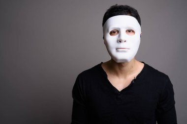 Gri arka planda genç yakışıklı bir adamın portresi