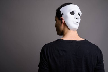 Gri arka planda genç yakışıklı bir adamın portresi