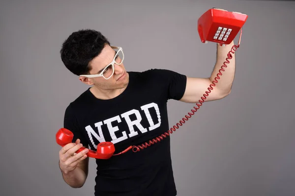 Young handsome nerd man with eyeglasses against gray background — Stock Photo, Image