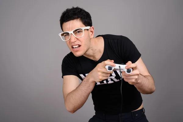 Joven hombre nerd guapo con anteojos sobre fondo gris —  Fotos de Stock
