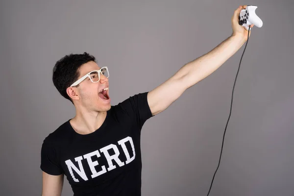 Jovem nerd bonito homem com óculos contra fundo cinza — Fotografia de Stock