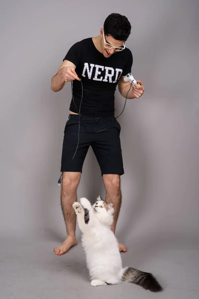 Joven hombre nerd guapo con anteojos sobre fondo gris —  Fotos de Stock