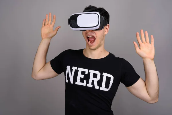 Jovem bonito nerd homem vestindo virtual realidade fone de ouvido — Fotografia de Stock