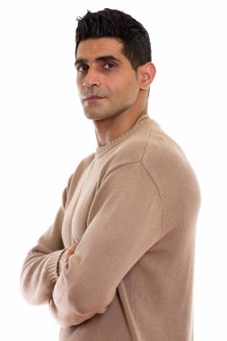 Kollarını kavuşturmuş genç kaslı İranlı adamın stüdyo fotoğrafı.