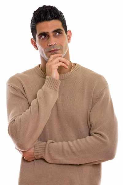 Studio shot of young muscular Persian man thinking with hand on — Stock Photo, Image