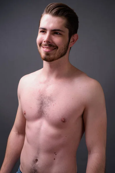 Young handsome bearded man shirtless against gray background — Stock Photo, Image