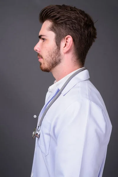 Jeune beau barbu homme médecin sur fond gris — Photo