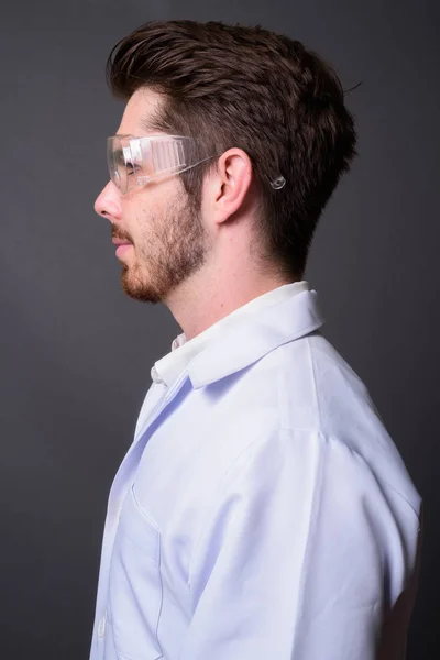 Молодой красивый бородатый врач в защитных очках ага — стоковое фото