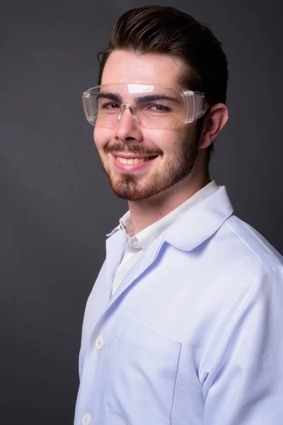 Молодий красивий бородатий чоловік лікар в захисних окулярах — стокове фото
