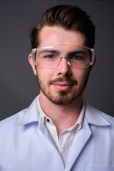 Studioaufnahme Eines Jungen Gutaussehenden Bärtigen Arztes Mit Schutzbrille Vor Grauem — Stockfoto