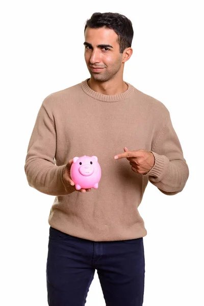 Portrait of young handsome Persian man with piggy bank — Stock Photo, Image
