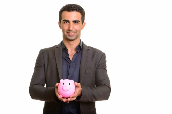 Persian businessman holding piggy bank against white background — Stock Photo, Image