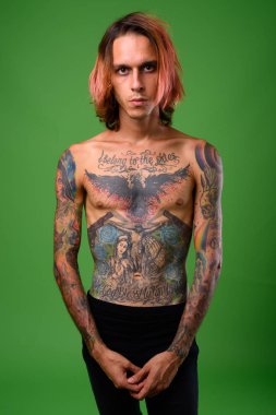 Asi genç adam karşı yeşil arka gömleksiz stüdyo çekim