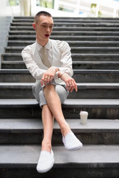 Jeune homosexuel androgyne LGTB homme d'affaires assis sur les escaliers — Photo