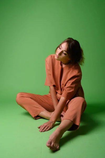 Yeşil arka planda genç ve güzel bir kadının stüdyo çekimi — Stok fotoğraf
